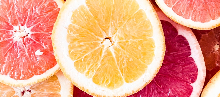 Fresh grapefruit cut in half showing pink flesh, on a clean surface